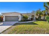 One-story home with gray garage door and well-manicured lawn at 714 Hidden Lake Dr, Tarpon Springs, FL 34689