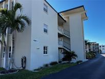 Exterior view of a multi-story building with palm trees and well-maintained landscaping on a sunny day at 9940 47Th N Ave # 102-C, St Petersburg, FL 33708