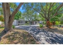 Charming single-story home with mature trees and beautifully landscaped front yard at 1201 77Th N St, St Petersburg, FL 33710