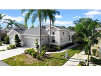 Gray two-story house with a two-car garage and lush landscaping at 1252 Lyndhurst Greens Dr, Sun City Center, FL 33573