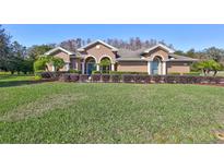 Beautiful home with a manicured lawn and lush landscaping at 2659 Keystone Springs Rd, Tarpon Springs, FL 34688