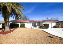 House exterior features red tile roof, light-colored siding, and landscaping at 6911 El Camino Paloma St, Port Richey, FL 34668