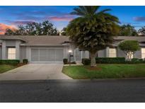 Charming single-story home with a well-maintained lawn and a two-car garage under a colorful sunset at 11121 Sun Tree Rd, Hudson, FL 34667