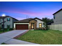 One-story home with brown garage door, stone accents, and landscaped lawn at 14610 Horse Trot Rd, Lithia, FL 33547