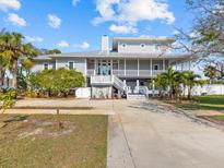 Two-story house with gray siding, white trim, and a large front porch at 1538 Riverside Dr, Tarpon Springs, FL 34689