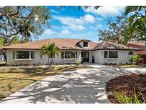 White single-story home with brown roof, landscaped yard, and circular driveway at 1621 Park N St, St Petersburg, FL 33710