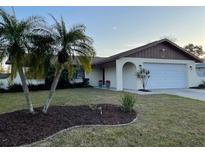 Charming single-story home featuring a well-maintained lawn and mature palm trees at 2134 Victory Ave, Largo, FL 33770