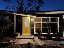 Inviting house exterior at night with a yellow door and well-lit walkway at 2311 Wellesley, Bradenton, FL 34207