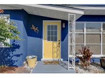 Close-up of the inviting yellow front door, creating a cheerful entrance to the home at 2311 Wellesley, Bradenton, FL 34207