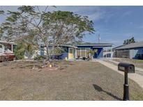 Charming blue house featuring a yellow door and a well-manicured front yard at 2311 Wellesley, Bradenton, FL 34207