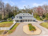 Two-story house with wrap-around porch, large backyard, and circular driveway at 3663 Berger Rd, Lutz, FL 33548