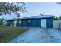 Ranch style home with a blue exterior, landscaping, and a driveway at 5108 Redwood Ter, North Port, FL 34286