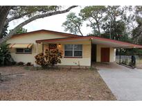 Charming single-story home with a front yard, carport and a covered entry at 5353 Shaw St, New Port Richey, FL 34652