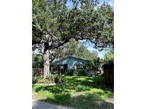 Charming home with large trees, lush landscaping, and a beautifully maintained yard at 2816 W Bay Ave, Tampa, FL 33611