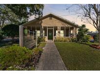 Tan house with green door, walkway, and landscaping at 931 And 925 Florida Ave, Palm Harbor, FL 34683