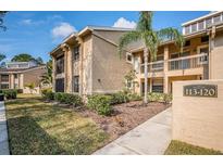 Well-maintained condo exterior with lush landscaping and a welcoming entryway at 113 Lindsay Ln # 23, Oldsmar, FL 34677