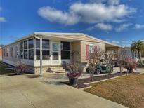 Charming single-story home with a well-manicured front yard, golf cart, and covered parking at 117 S Saint Thomas Cir, Apollo Beach, FL 33572