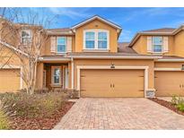 Charming two-story townhome featuring a two-car garage and a well-maintained brick driveway at 11811 Meadowgate Pl, Bradenton, FL 34211