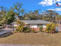 Charming single-story home featuring mature landscaping and a well-manicured lawn, complemented by a quaint design at 1276 Bermuda St, Clearwater, FL 33755