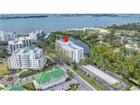 Stunning aerial view of the condo building with water views and lush landscaping at 220 Belleview Blvd # 108, Belleair, FL 33756