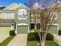 Green two-story townhome with attached garage and landscaping at 10120 Post Harvest Dr, Riverview, FL 33578