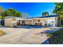 Inviting single-story home featuring carport, tidy landscaping, and a spacious concrete driveway at 10532 94Th Pl, Seminole, FL 33772