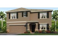 Two-story house with brown exterior, a two-car garage, and landscaping at 10596 Farm Hill Ave, Land O Lakes, FL 34638