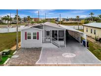 Charming single-story home with a screened porch, carport, and brick-paver driveway at 206 S Port Royal Ln, Apollo Beach, FL 33572