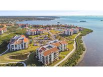 Stunning aerial view of waterfront condo community with lush landscaping and beautiful bay views at 301 Mariner Dr # 301, Tarpon Springs, FL 34689