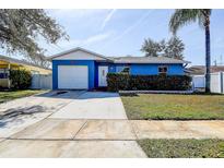 Charming blue single-story home featuring an attached garage, well-kept lawn, and a classic front door at 4570 69Th N Ave, Pinellas Park, FL 33781