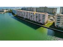 Aerial view of condo building on waterfront with pool and surrounding area at 6025 Shore S Blvd # 504, Gulfport, FL 33707