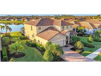 Stunning home featuring a tile roof, manicured landscaping, and a serene waterfront view at 6467 Willowshire Way, Bradenton, FL 34212