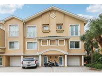 Attractive three-story townhouse with a private garage, covered entry, and well-maintained landscaping at 684 Bayway Blvd, Clearwater, FL 33767