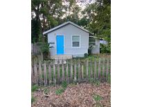 Gray house with blue door, picket fence, and small yard at 8004 N 11Th St, Tampa, FL 33604