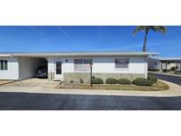 Charming home with a single-car carport, well-maintained landscaping, and a stone facade, set against a bright blue sky at 12400 Park Blvd # 417, Seminole, FL 33772