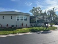 Charming home exterior with a covered porch and well-maintained landscaping in a serene neighborhood at 12501 Ulmerton Rd # 10, Largo, FL 33774