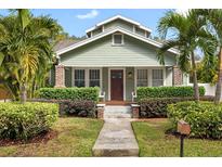 Charming home with green siding, lush landscaping, and a welcoming front porch at 205 W North St, Tampa, FL 33604