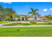 Elegant single-story home featuring lush landscaping, a circular driveway, and stately palm trees at 5501 E Longboat Blvd, Tampa, FL 33615