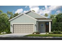 Charming single-Gathering home featuring a two-car garage, neutral colors, and professionally landscaped front yard at 750 Steel Dr, Apollo Beach, FL 33572