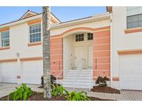 Inviting condo exterior with peach accents, white trim, and manicured landscaping at 7532 Marsh Orchid Cir # 8-201, Bradenton, FL 34203