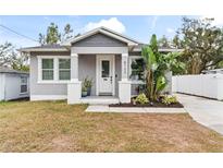 Charming craftsman style home with gray siding, white trim, and a landscaped front yard at 8723 N Calder Pl, Tampa, FL 33604