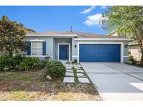 Charming one-story home with blue door, shutters and well-manicured landscaping at 20327 Merry Oak Ave, Tampa, FL 33647