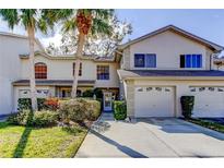 Charming townhome featuring an attached garage, well-maintained landscaping, and a welcoming entrance at 2559 Stony Brook Ln, Clearwater, FL 33761