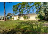 Single-story home with a well-manicured lawn and mature trees at 3241 Rogue St, North Port, FL 34291