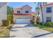 Charming two-story home with a well-kept lawn, featuring a two-car garage and a red-tiled roof at 6105 Mirada Cir, St Petersburg, FL 33715