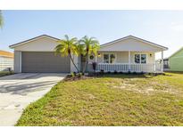 Charming single-story home with a well-manicured lawn, beautiful landscape, and a cozy front porch at 6121 38Th W Ave, Bradenton, FL 34209