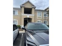 Exterior view of the condo building featuring a carport and visible unit number at 6439 Cypressdale Dr # 202, Riverview, FL 33578