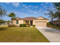 Charming single-story home featuring a well-manicured lawn, mature landscaping, and a two-car garage at 7304 63Rd E Ct, Palmetto, FL 34221