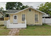 Charming yellow bungalow with stone facade and covered front porch at 1200 13Th St N, St Petersburg, FL 33705