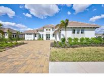 Stunning exterior of a two-story home featuring a well-manicured lawn and a beautiful brick driveway at 1201 Blue Shell Loop, Sarasota, FL 34240